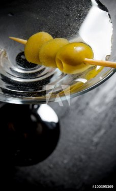 Martini with olives on a black table. Free space for text.