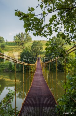 metal suspension bridge over the river - 901139987