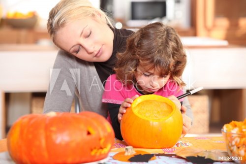 Mother and daughter preparing pumpkin in kitchen - 900444079