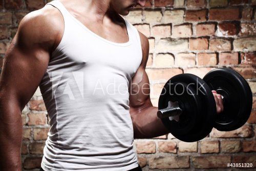 Muscular guy doing exercises with dumbbell - 900601524