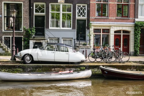 Old citroen ds sedan on a bridge over a canal in Amsterdam - 901153094