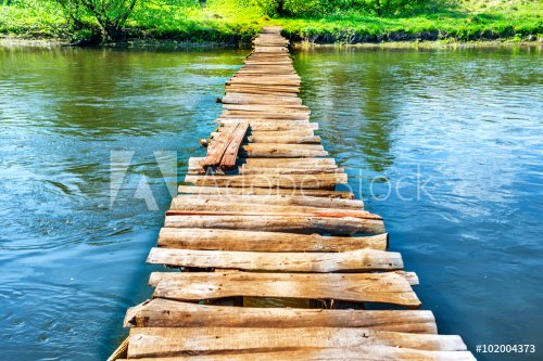 Old wooden bridge through the river - 901147948
