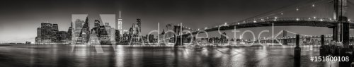 Panoramic Black and white view of Lower Manhattan Financial District skyscrapers at twilight with the Brooklyn Bridge and East River. New York City