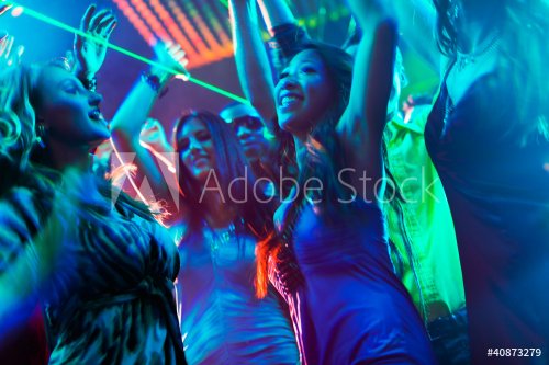 Party people dancing in disco or club
