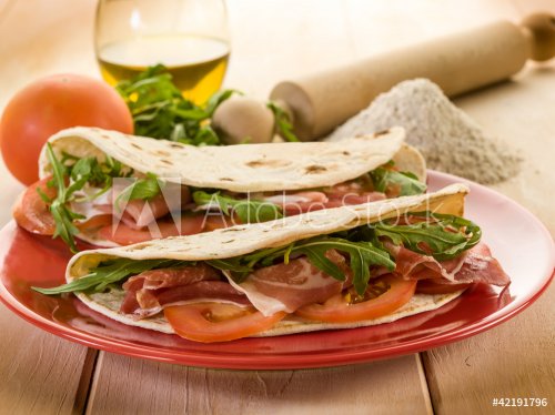 piadina with ham arugula and tomatoes, typical italian sandwich - 900430385