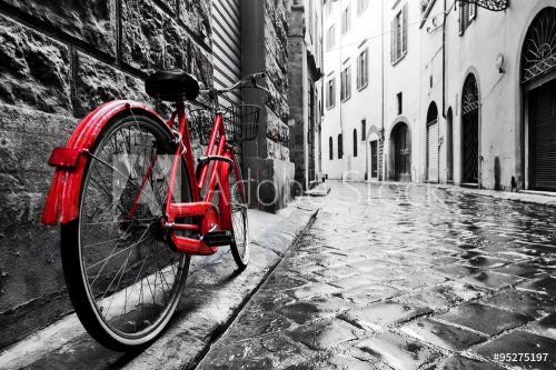 Retro vintage red bike on cobblestone street in the old town. Color in black and white