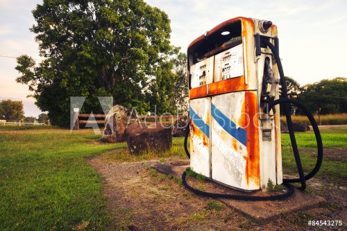 Rusted on pump put the front of an abandoned fuel station. - 901145098