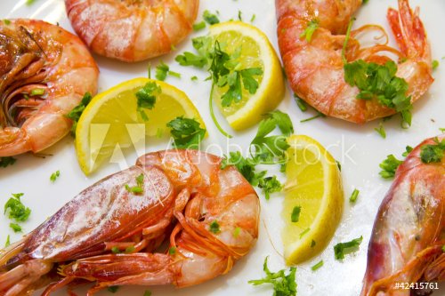 Shrimps with lemon slices and parsley on white plate - 900572927