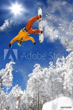 Snowboarder jumping against blue sky - 901151592