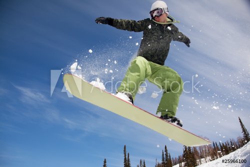 Snowboarder jumping through air with  blue sky in background - 900101679