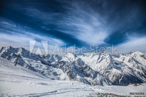 Snowy peaks against the blue sky - 901148046