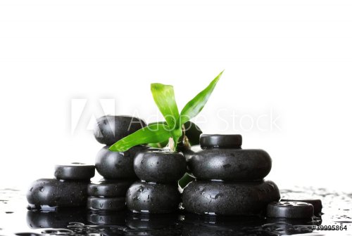 Spa stones with drops and green bamboo on white background