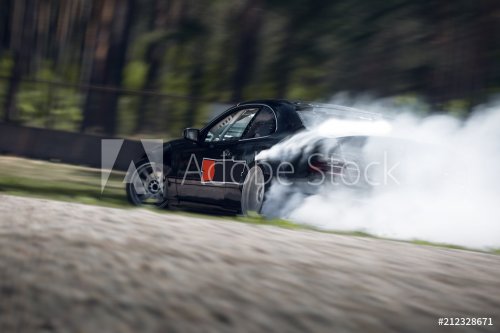 Sport car wheel drifting. Blurred of image diffusion race drift car with lots of smoke from burning tires on speed track