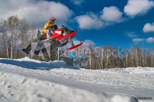 Sport red snowmobile jump. Sunny winter day with blue sky. Concept quick move... - 901151610
