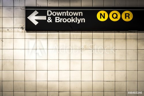 Subway sign in Manhattan directing passengers  and travelers to the downtown and Brooklyn trains