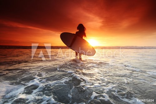 Surfer woman on beach at sunset - 901148786