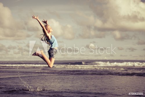 teen girl  jumping on the beach at blue sea shore in summer vaca - 901144123