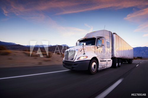 Truck and highway at sunset - transportation background - 901154264