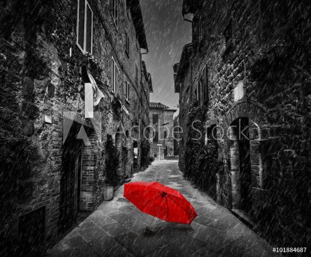 Umbrella on dark street in an old Italian town in Tuscany, Italy. Raining.