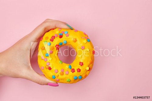 Woman holding delicious donut on color  background - 901152484