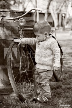 2 years old curious Baby boy walking around the old bike - 901144083
