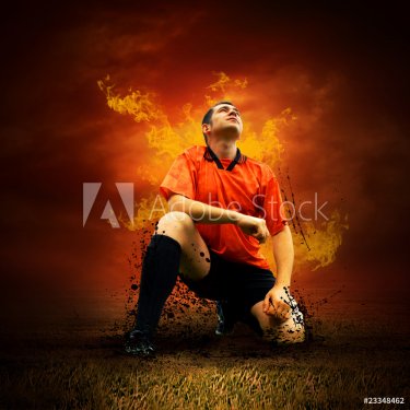Football player in fires flame on the outdoors field - 900416829