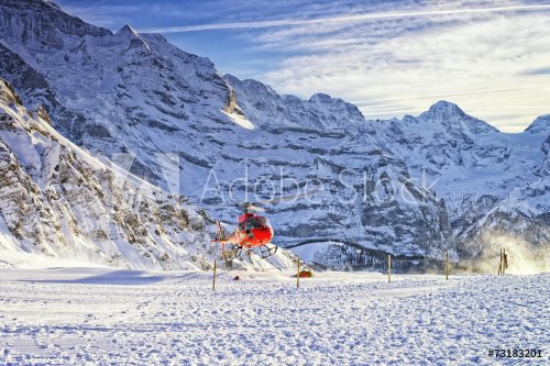 Red helicopter take off  at swiss ski resort near Jungfrau mount - 901145616