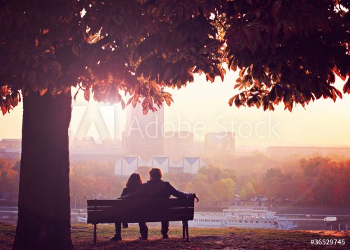 Romantic Couple on a Bench by the River in Autumn - 900868419