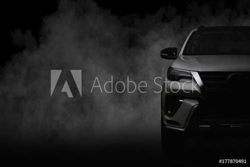 Studio shot of white car isolated on black background with shadow and smoke fog.