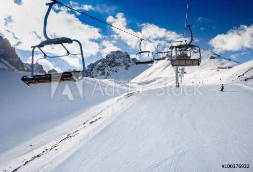 Winter mountains panorama with ski slopes and ski lifts. Skiers going down th... - 901146455