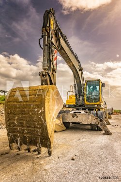 Excavator to level and smooth the land in the construction of a road - 901156358