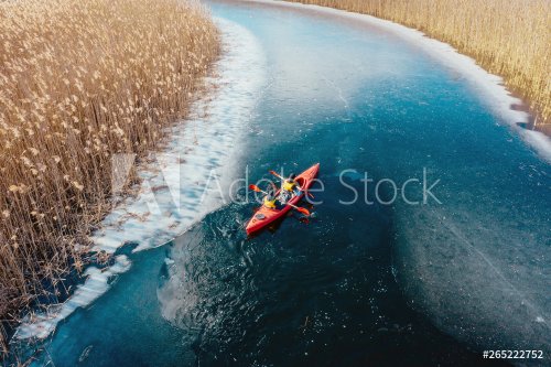 two athletic man floats on a red boat in river - 901156371