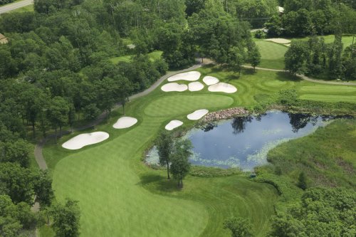 Vue aérienne du golf fairway et green avec pièges, étang et arbres