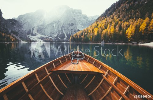 Wooden rowing boat on a lake in the Dolomites in fall - 901156851