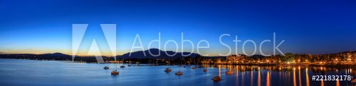 Magog town at night in reflections of Memphremagog lake. Canadian romantic landscape with mountains, lake, night sky and awesome water background.