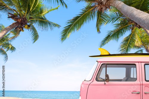 Vintage car parked on the tropical beach (seaside) with a surfboard on the ro... - 901157218
