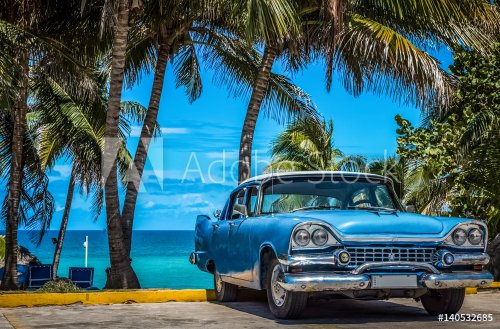 Blauer amerikanischer Oldtimer parkt am Strand unter Palmen in Varadero Kuba - Serie Kuba Reportage