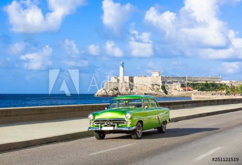 Voiture classique cabriolet vert américain sur le célèbre Malecon et en arrière-plan la forteresse Castillo de los Tres Reyes del Morro à La Havane Cuba