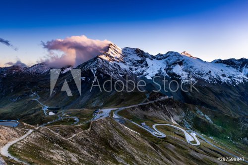 Dramatic Sunset at Snowy Mountains Peaks and High Alpine Road