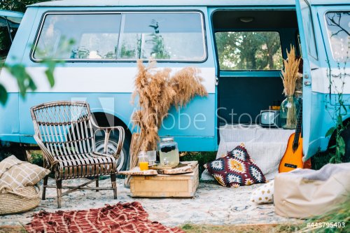 Cozy place near blue van with wooden chair and mini table.