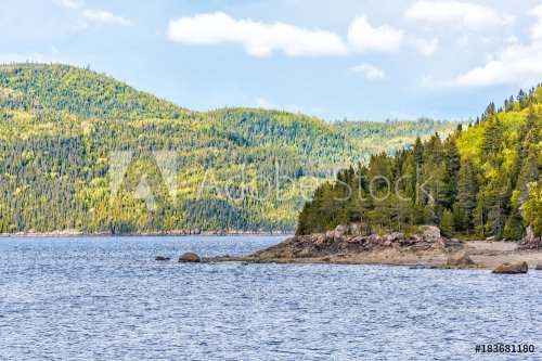 Fjord coast nature near Saguenay river, cliffs, tree forest, mountains and cloudy clouds sky