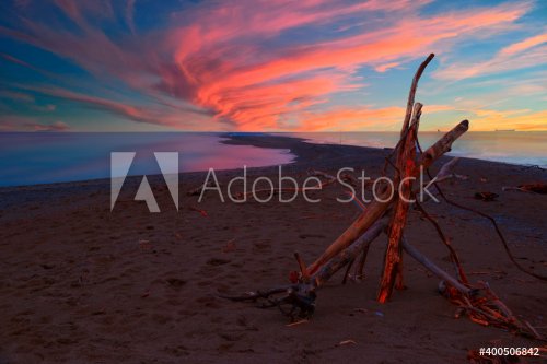 A small structure made of branches and twigs sits on a narrow beach at Point Pelee National Park in Ontario, looking towards the southernmost point in mainland Canada during a beautiful sunset..