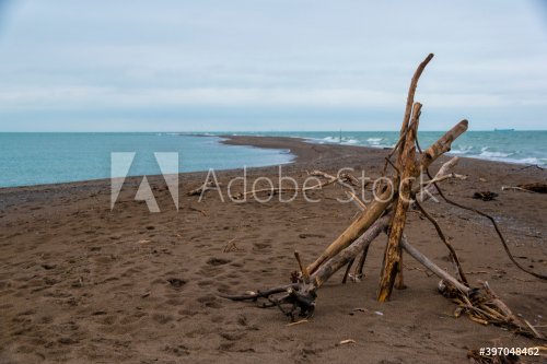 A small structure made of branches and twigs sits on a narrow beach at Point Pelee National Park in Ontario, looking towards the southernmost point in mainland Canada