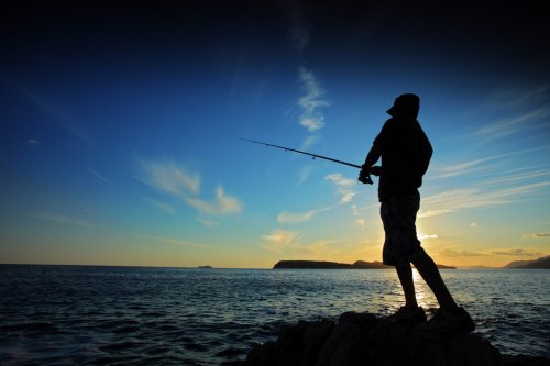 Man fishing on sunset - 900188309