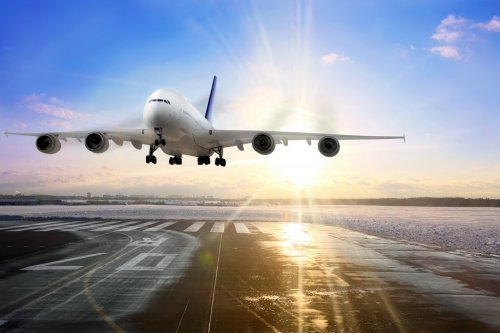 Passenger airplane landing on runway in airport. Evening - 900374183