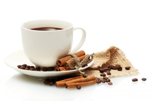 cup of coffee, beans and cinnamon sticks isolated on white