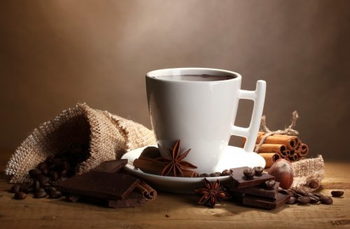 cup of hot chocolate, cinnamon sticks, nuts and chocolate