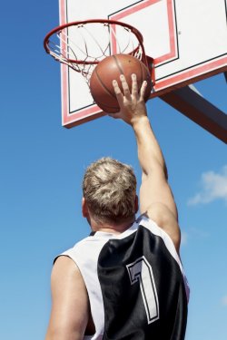 Basketball player throws ball in the basket