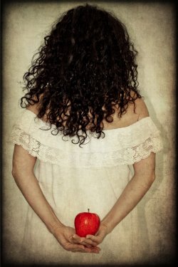 Donna di spalle che tiene una mela rossa - 900573026