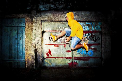 Young man jumping on grunge graffiti wall - 901140326